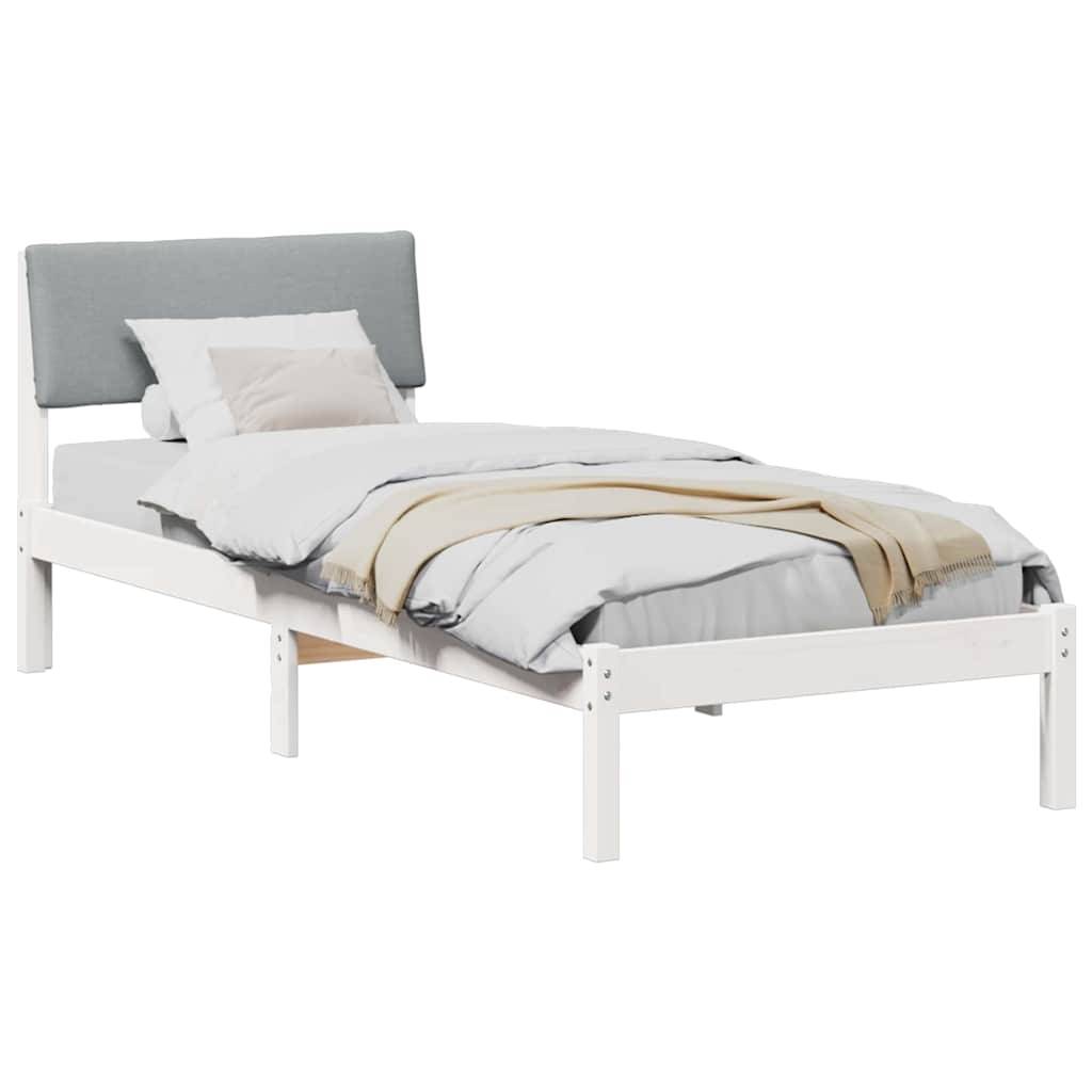 Ein Einzelbett mit einem weißen Rahmen und einem hellblauen Kopfteil, ordentlich bezogen mit weißer Bettwäsche, einer beigen Decke und zwei Kissen.