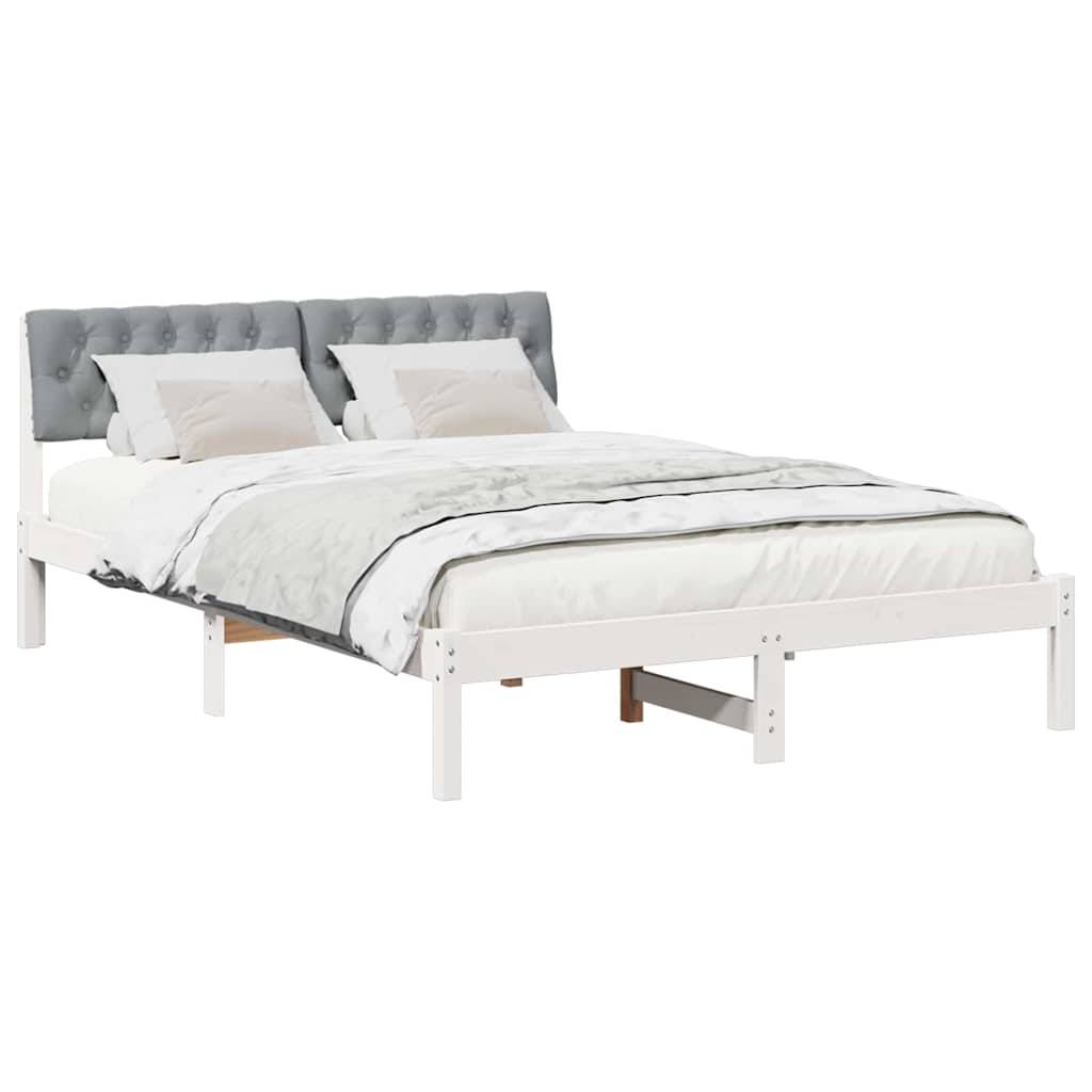 Ein weißer Bettrahmen mit einem gepolsterten grauen Kopfteil, versehen mit einem ordentlich gemachten Bett mit weißer Bettwäsche und zwei Kissen.