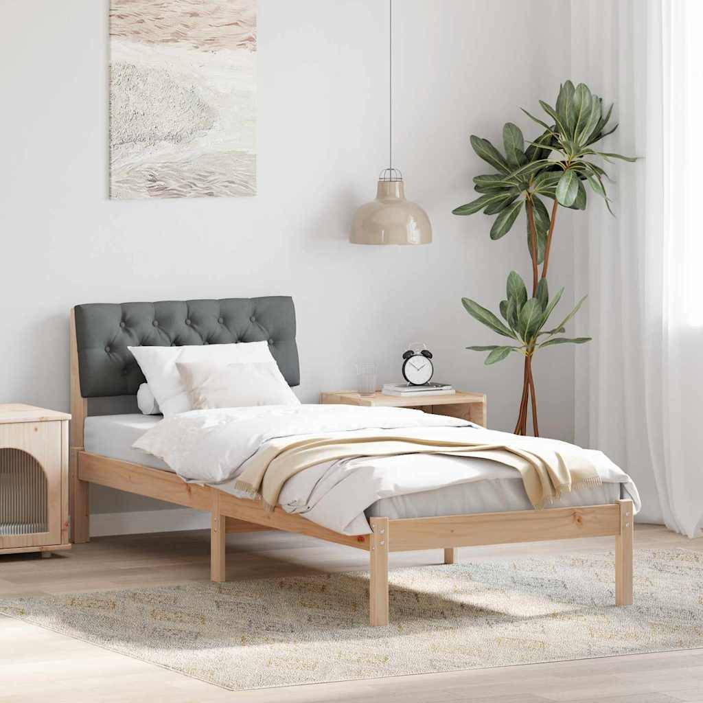 Minimales Schlafzimmer mit einem gemachten Einzelbett, grauem gestepptem Kopfteil, Nachttisch und Lampe, Wandkunst, Topfpflanze und weichem Naturlicht.