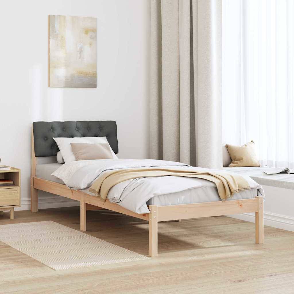 Ein minimalistisches Schlafzimmer mit einem Holzbett, das graue Bettwäsche, ein weiches Kopfende und Kissen aufweist. Ein Gemälde und Vorhänge dienen als Dekoration.