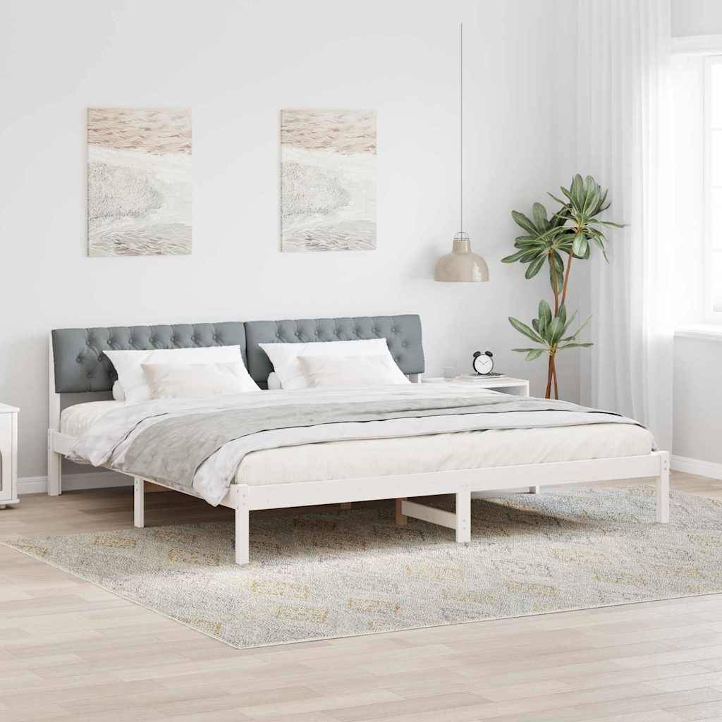 Ein modernes Schlafzimmer verfügt über ein Doppelbett mit einem grauen Kopfteil, zwei abstrakten Gemälden darüber und einen kleinen Nachttisch mit einer Pflanze in der Nähe.
