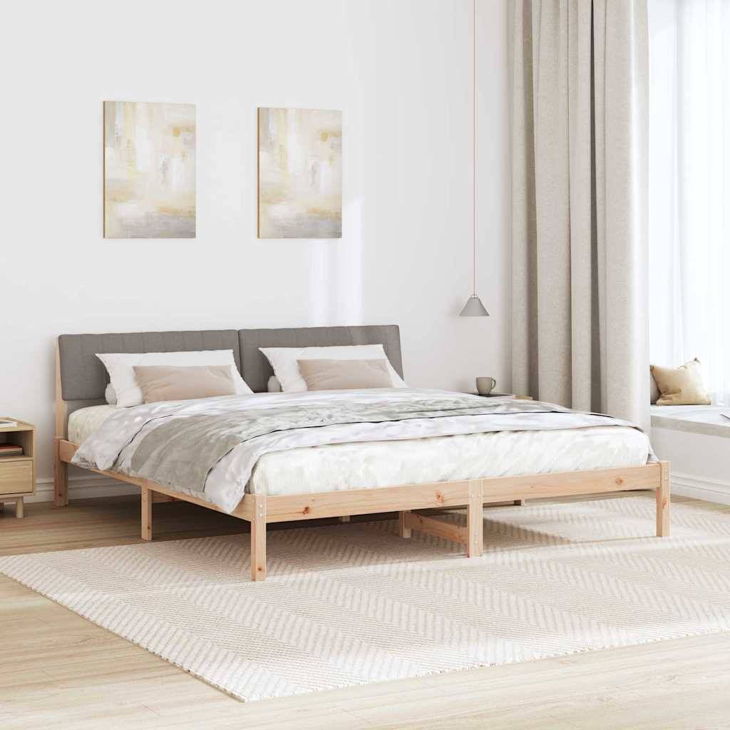 Ein modernes Schlafzimmer mit einem Holzbett, einem grauen Kopfteil, beige Bettwäsche, hellholzfarbenen Nachttischen, einer Pendelleuchte und abstrakten Kunstwerken.