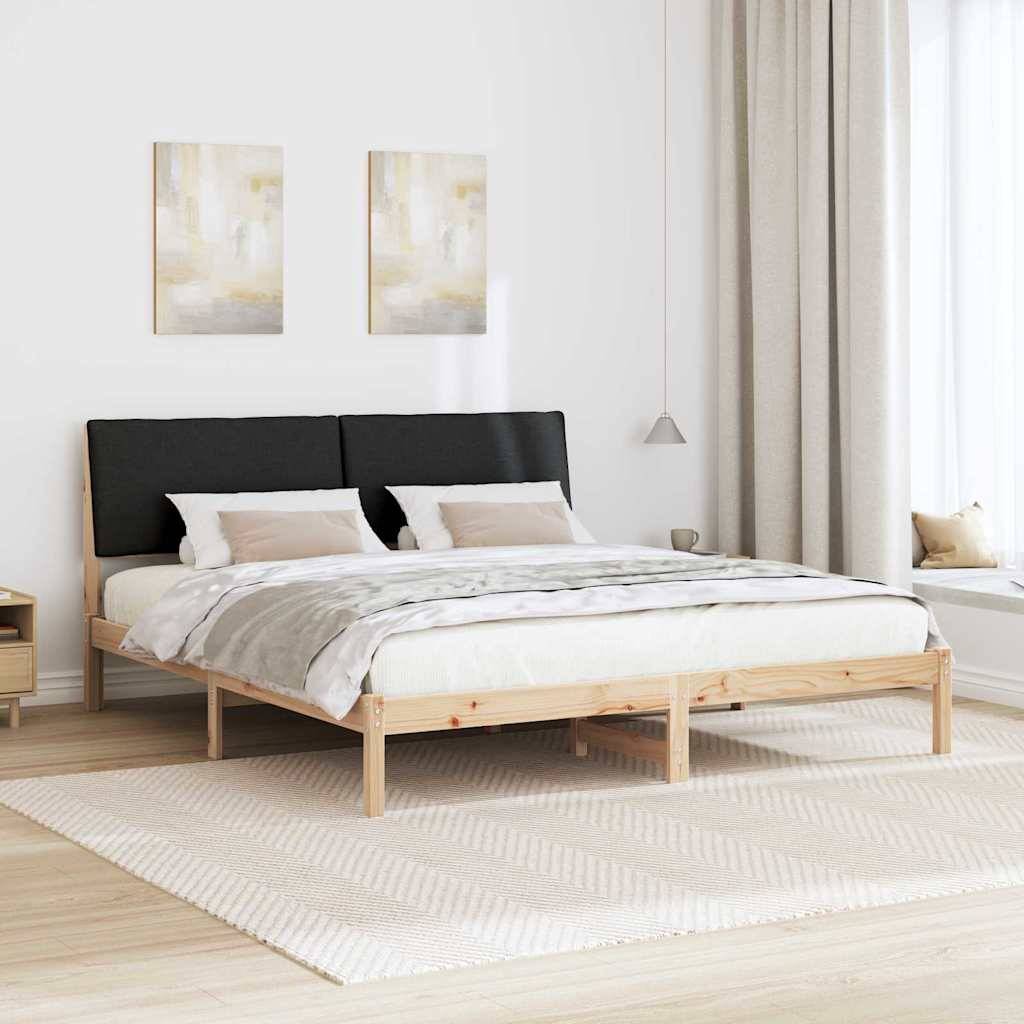 Ein modernes Schlafzimmer zeigt ein Holzbett mit grau-beiger Bettwäsche, zwei abstrakten Gemälden darüber, einem Nachttisch links und einem großen Fenster mit beigen Vorhängen rechts.