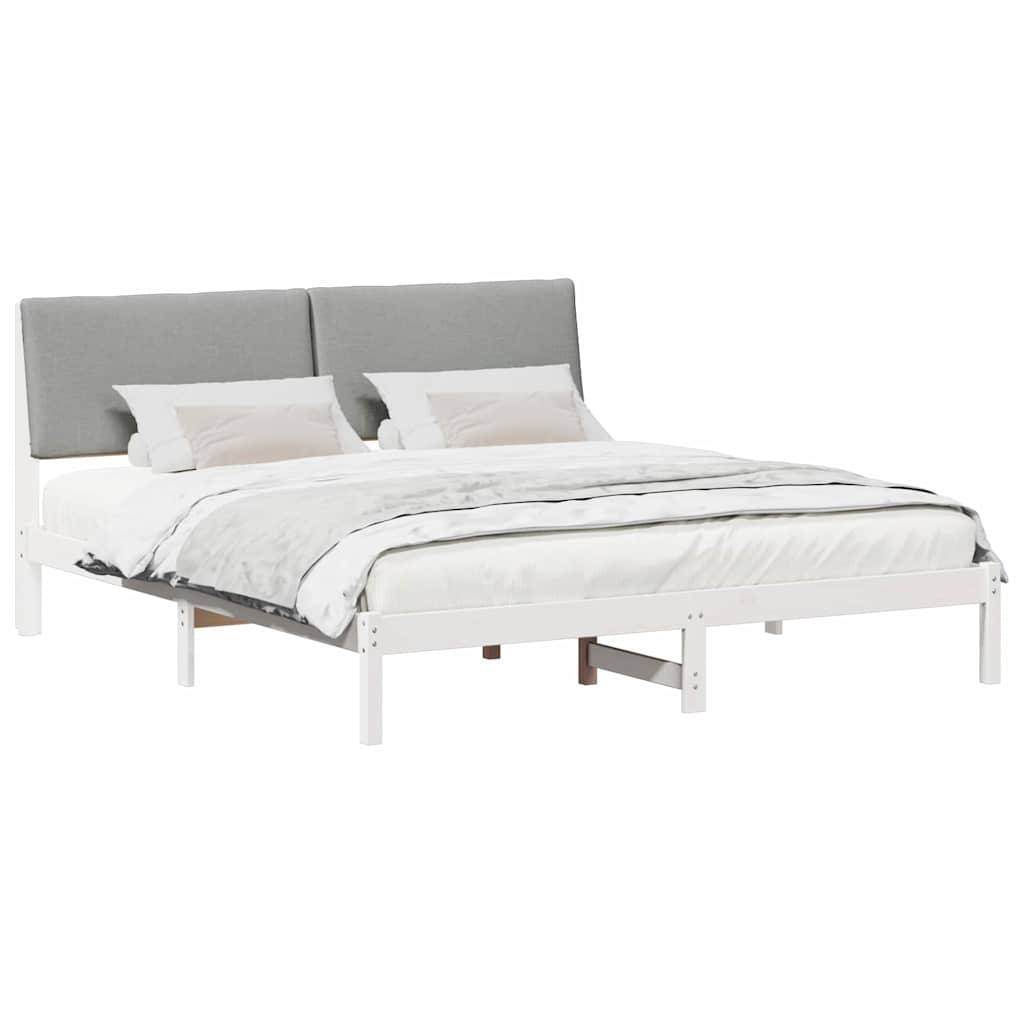 Ein modernes Doppelbett mit einem hellgrauen gepolsterten Kopfteil und weißem Rahmen, ausgestattet mit ordentlich bezogener Bettwäsche in Weiß und zwei Kissen.