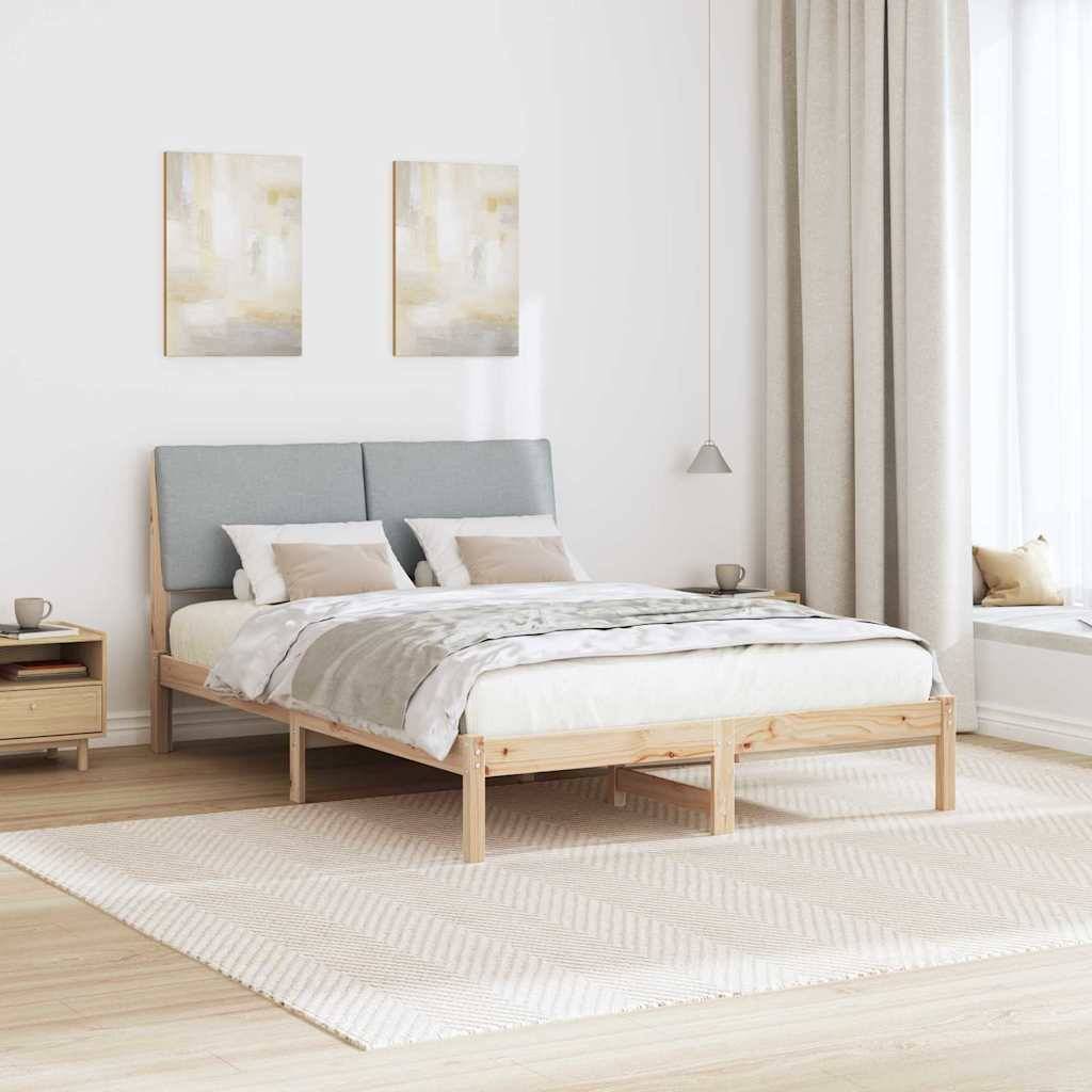Ein minimalistisches Schlafzimmer mit einem Holzbett, grauem Kopfteil, beiger Bettwäsche, zwei Gemälden, einem Nachttisch und einer Fensternische mit Vorhängen.