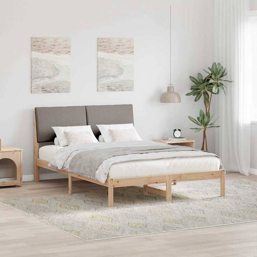 Ein modernes Schlafzimmer mit einem Holzbett, grauen Bettwäsche, zwei abstrakten Kunstwerken über dem Kopfteil, einem Nachttisch, einer Lampe und einer großen Pflanze.
