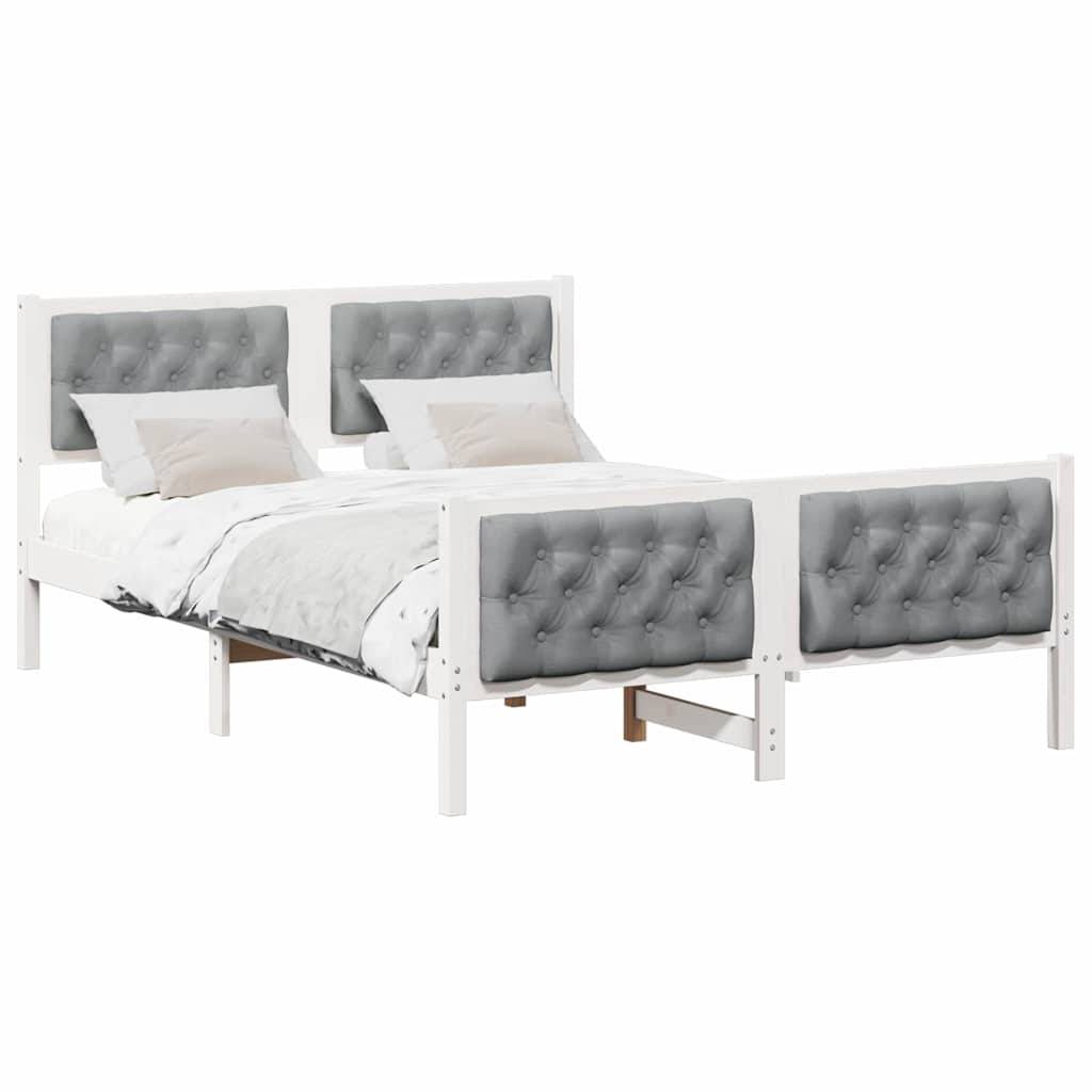 Ein Bett mit einem weißen Holzrahmen und einem grau gepolsterten Kopf- und Fußteil, ausgestattet mit weißer Bettwäsche und vier beigen Kissen.