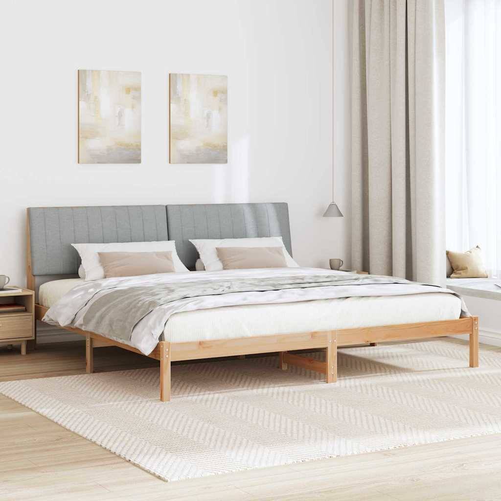 Helles minimalistisches Schlafzimmer mit niedrigem Holzbett, grauem Polsterkopfteil, weißer Bettwäsche, Nachttischen, Vorhängen und Wandkunst.
