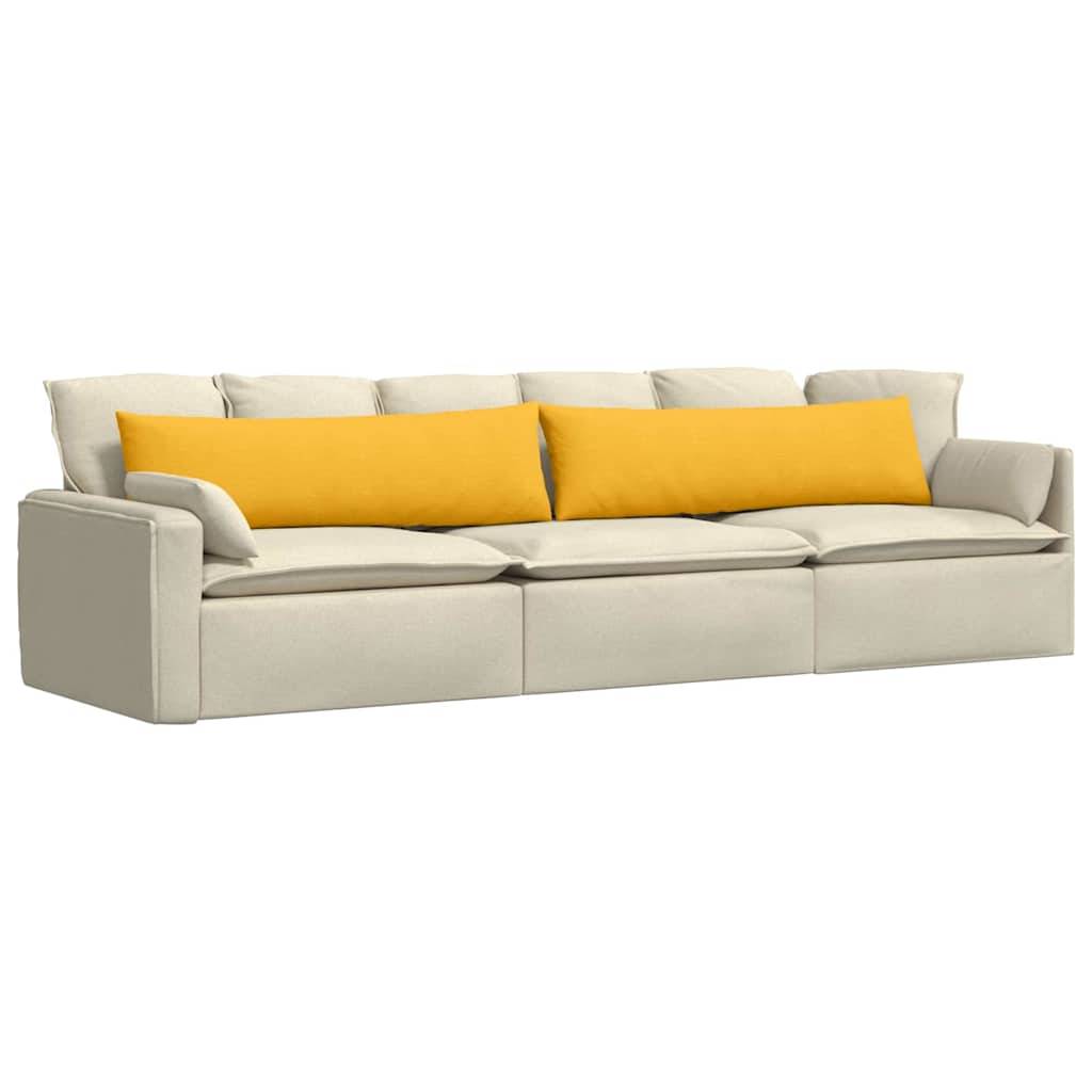 Ein beiges Dreisitzer-Sofa mit großen gelben Kissen auf weißem Hintergrund.