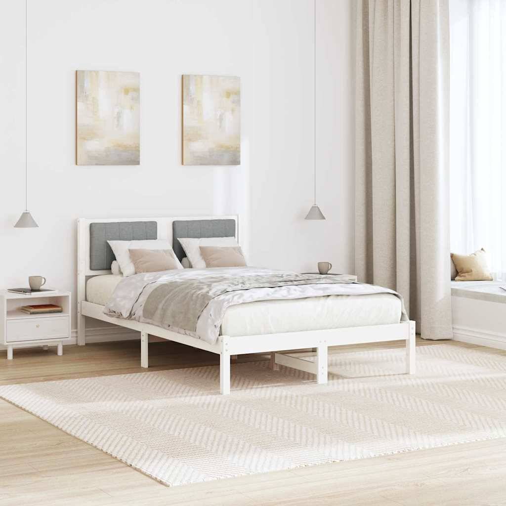 Ein gemütliches Schlafzimmer mit einem ordentlich gemachtem Bett, das mit grauen und beigefarbenen Betttüchern ausgestattet ist, flankiert von zwei kleinen Pendelleuchten, in einer sanft beleuchteten modernen Umgebung.