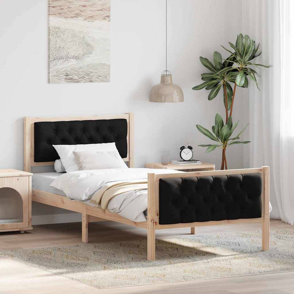 Modernes Schlafzimmer mit einem Einzelbett, schwarzem gestepptem Kopf- und Fußteil, weißer Bettwäsche, Nachttisch, hängender Lampe, Pflanze und Wandkunst.