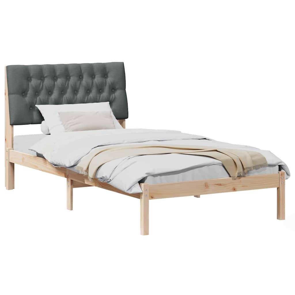 Ein modernes Einzelbett mit hellem Holzrahmen, grauem gestepptem Polsterkopfteil, weißer Bettwäsche und einer gefalteten beigen Wurfdecke auf weißem Hintergrund.
