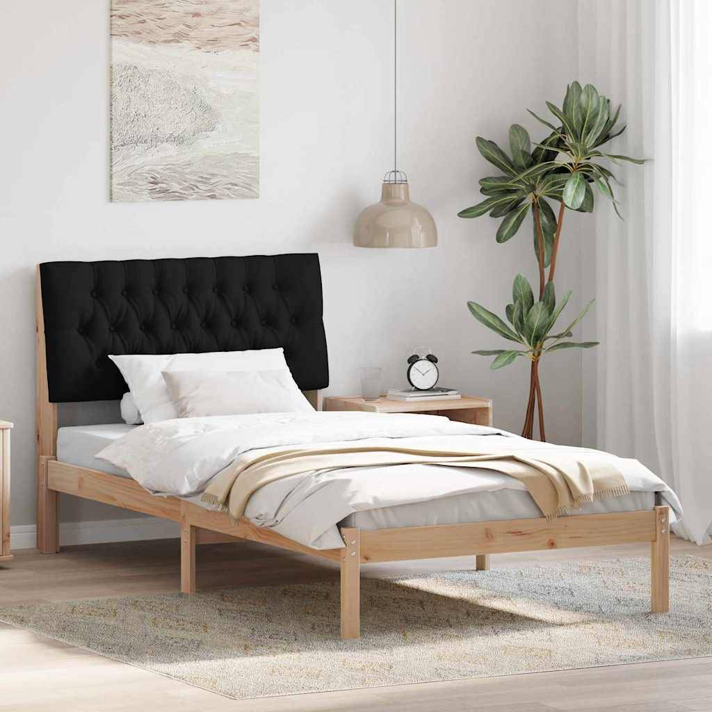 Modernes Schlafzimmer mit einem Bett aus hellem Holz, schwarzem gestepptem Kopfteil, weißer Bettwäsche, hängender Lampe, Nachttisch mit Wecker und Topfpflanze.