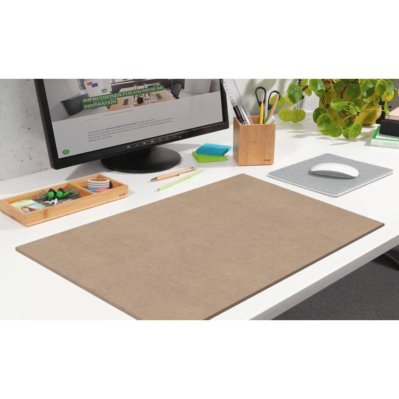 Ein aufgeräumter Arbeitsplatz mit einem Monitor, dessen Text unkenntlich ist, einem braunen Schreibtischunterlagen, Stiften in einem Tablett und einer kleinen Pflanze in einem Topf.