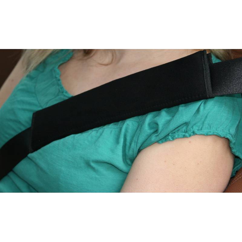 Eine Person, die ein petrolblaues Shirt trägt und einen Sicherheitsgurt über der Schulter hat, was die Sicherheit beim Fahren oder Mitfahren in einem Fahrzeug betont.