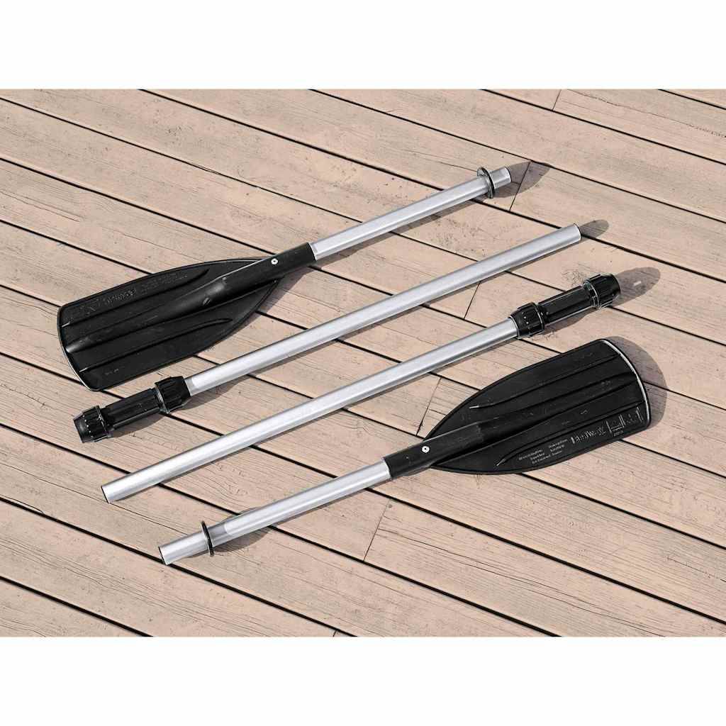 Drei abnehmbare Kajak-Paddel mit schwarzen Blättern und silbernen Schäften liegen zerlegt auf einem hellen Holzdeck.