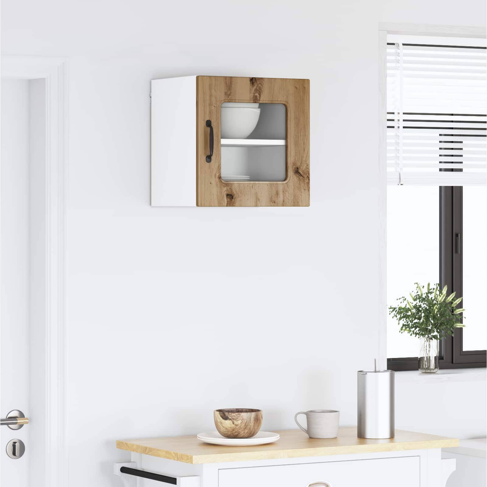 Eine moderne Küchenecke mit einem Holz- und weißen Schrank an der Wand, einer kleinen Pflanze auf der Arbeitsplatte und einem Schneidebrett mit einer Schüssel.