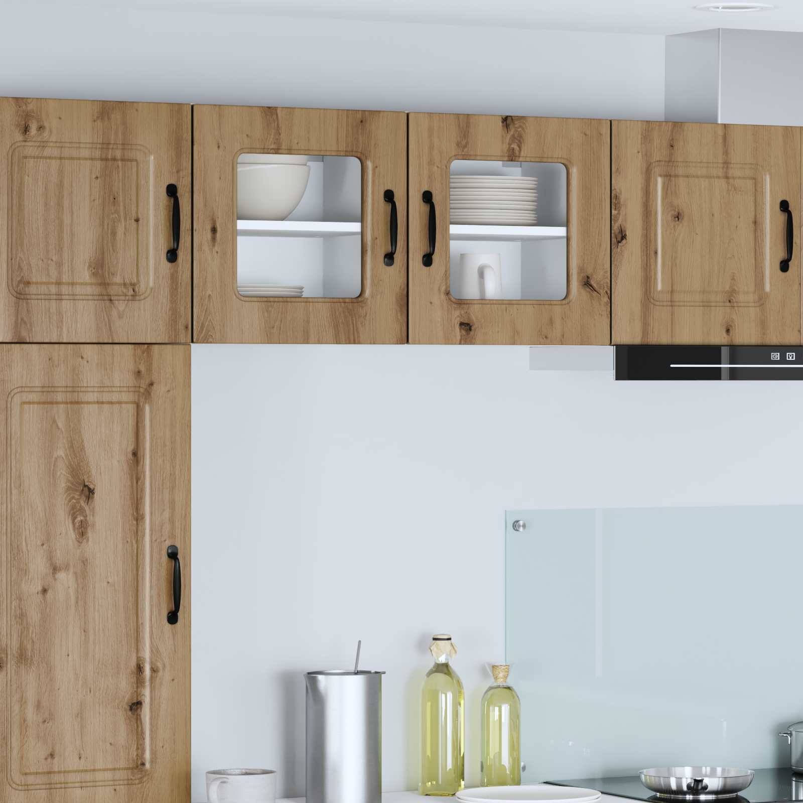 Holzküchenschränke mit schwarzen Griffen und Glastürregalen über einer Arbeitsplatte mit Metallbehältern, Ölflaschen und einer Glasrückwand.