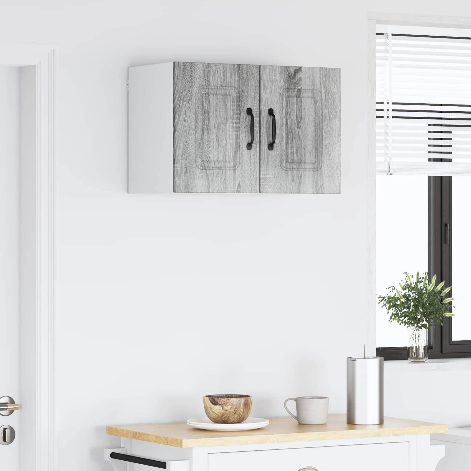 Eine minimalistische Küchenszene mit einer Holzarbeitsplatte, einer kleinen Topfpflanze neben einem Fenster und einem an der Wand montierten Schrank darüber.