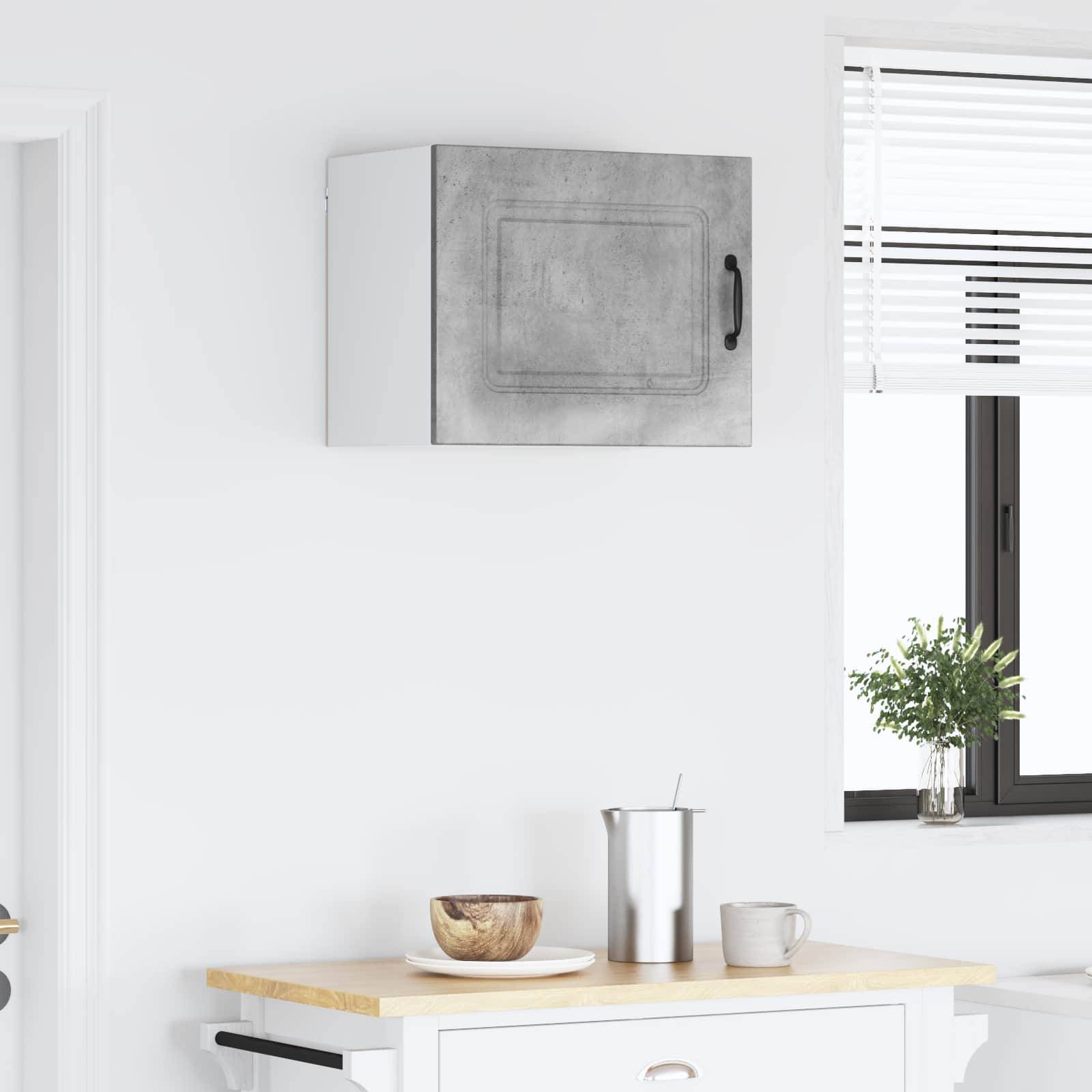 Eine minimalistische Küche mit einer weißen Wand, einer Holzarbeitsplatte, einer kleinen Schüssel und einem Metallbehälter. Ein Fenster mit Jalousien lässt natürliches Licht herein.