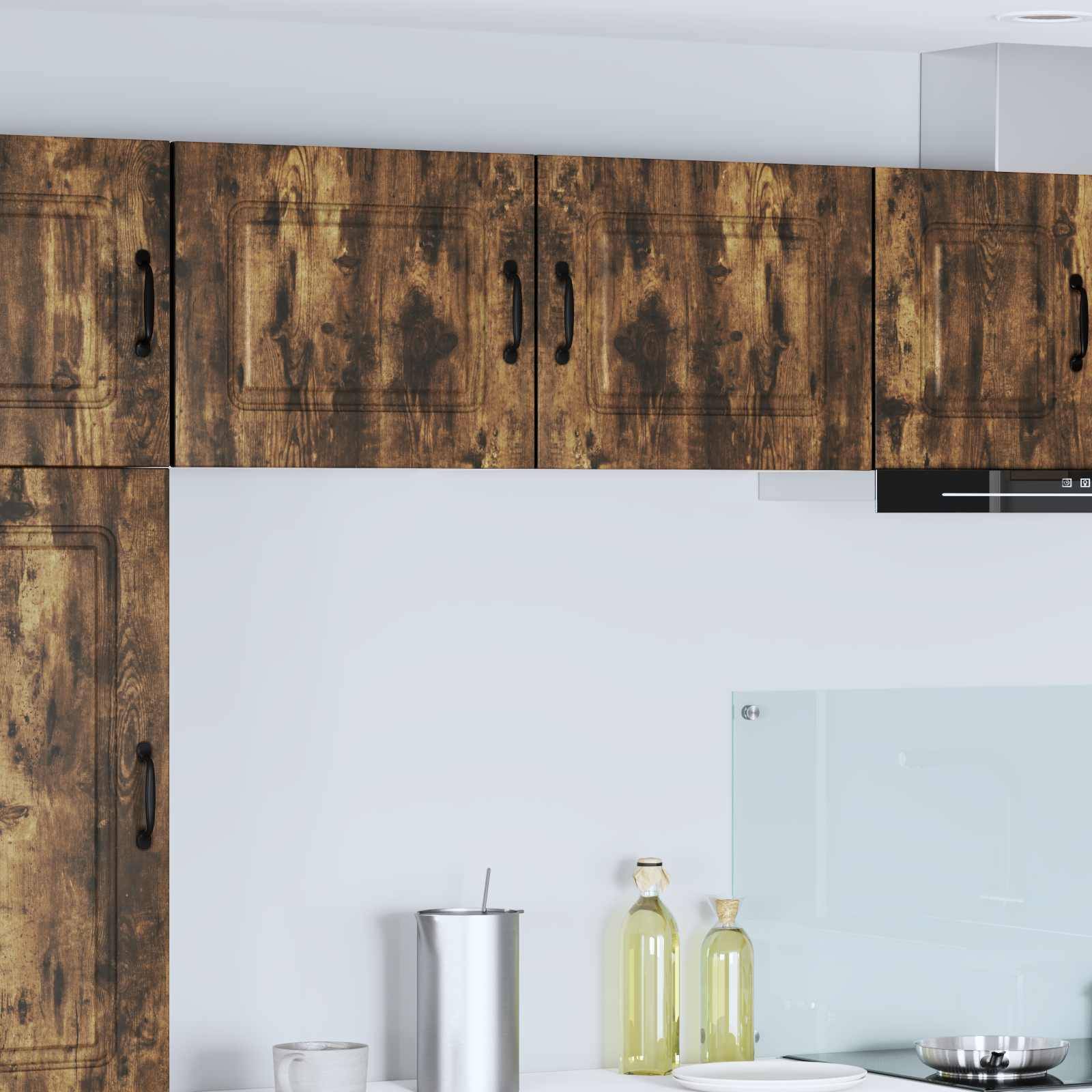 Holzküchenschränke mit natürlicher Maserung, ein silberner Becher und Olivenölflaschen auf einer weißen Arbeitsplatte; modernes und minimalistisches Design.