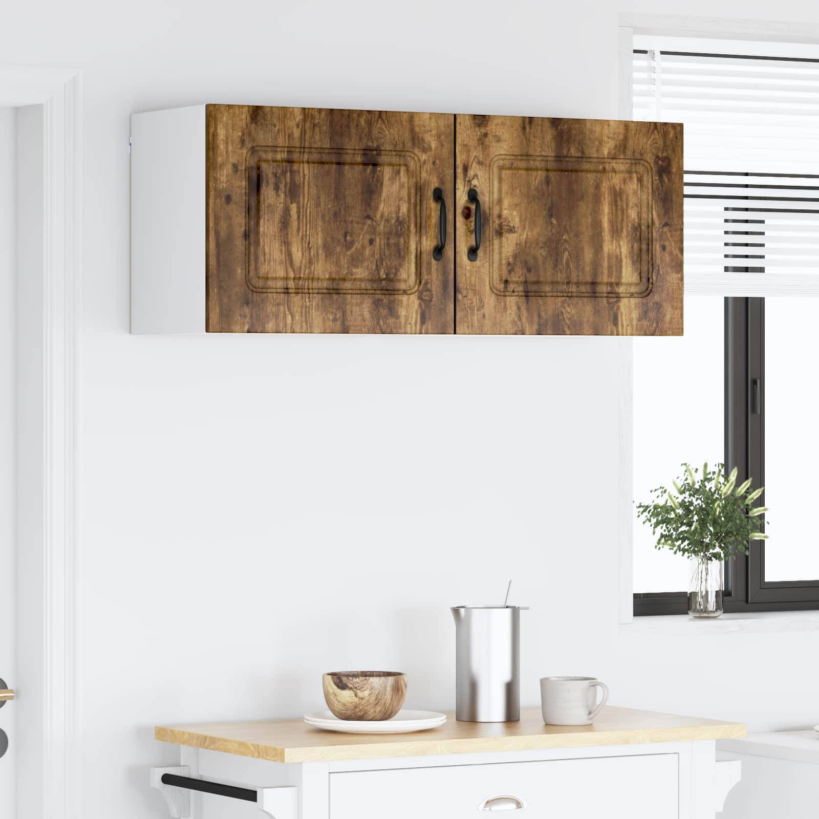 Eine moderne Küche mit Holzschränken, einer Arbeitsplatte mit einer Schüssel, einem Metallbehälter und einer Tasse, wobei natürliches Licht durch ein Fenster hereinfällt.