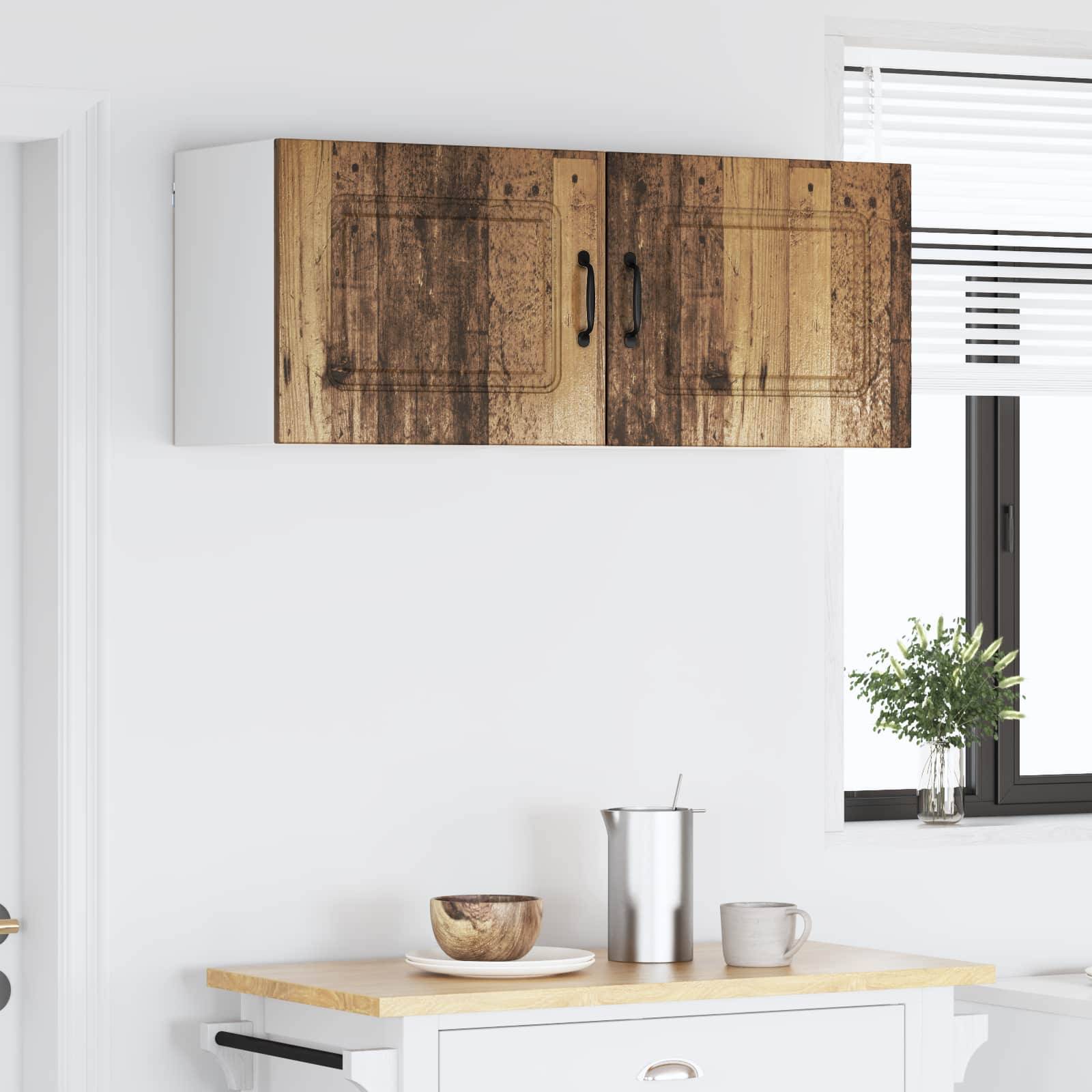 Eine moderne Küchenszene mit einem rustikalen Holzschrank, einer Edelstahl-Kaffeekanne, einer kleinen Schüssel und einer Tasse auf der Arbeitsplatte unter natürlichem Licht.