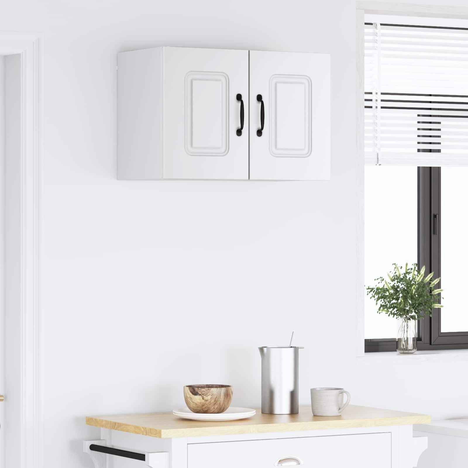 Eine minimalistische Küche mit einem weißen Schrank, einem Fenster mit Jalousien, einer Holzarbeitsplatte und Gegenständen wie einer Schüssel, einem Behälter und einer Tasse.