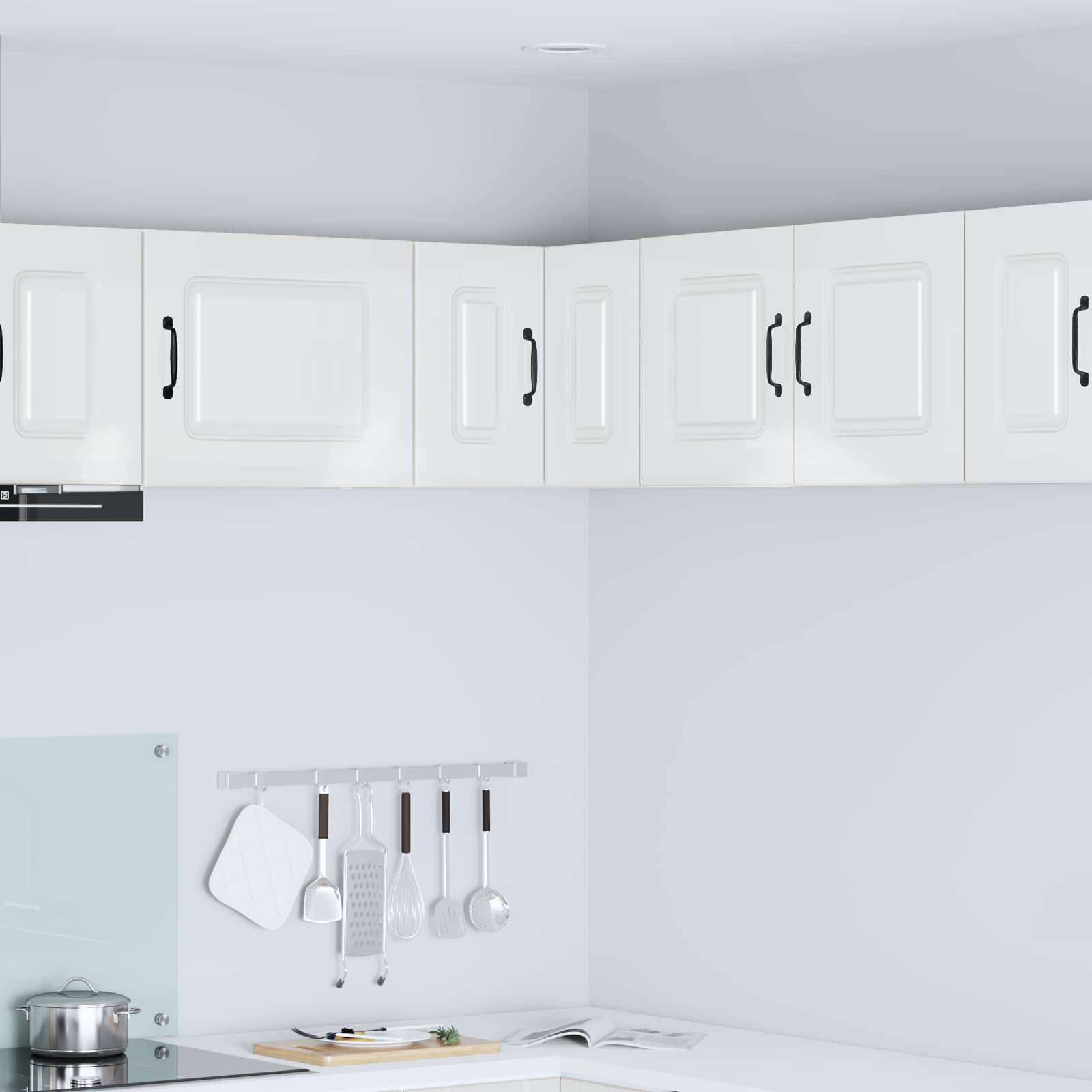 Moderne Küche mit weißen Schränken und minimalistischem Design. Edelstahl-Küchenutensilien hängen an einer Schiene über der Arbeitsplatte.
