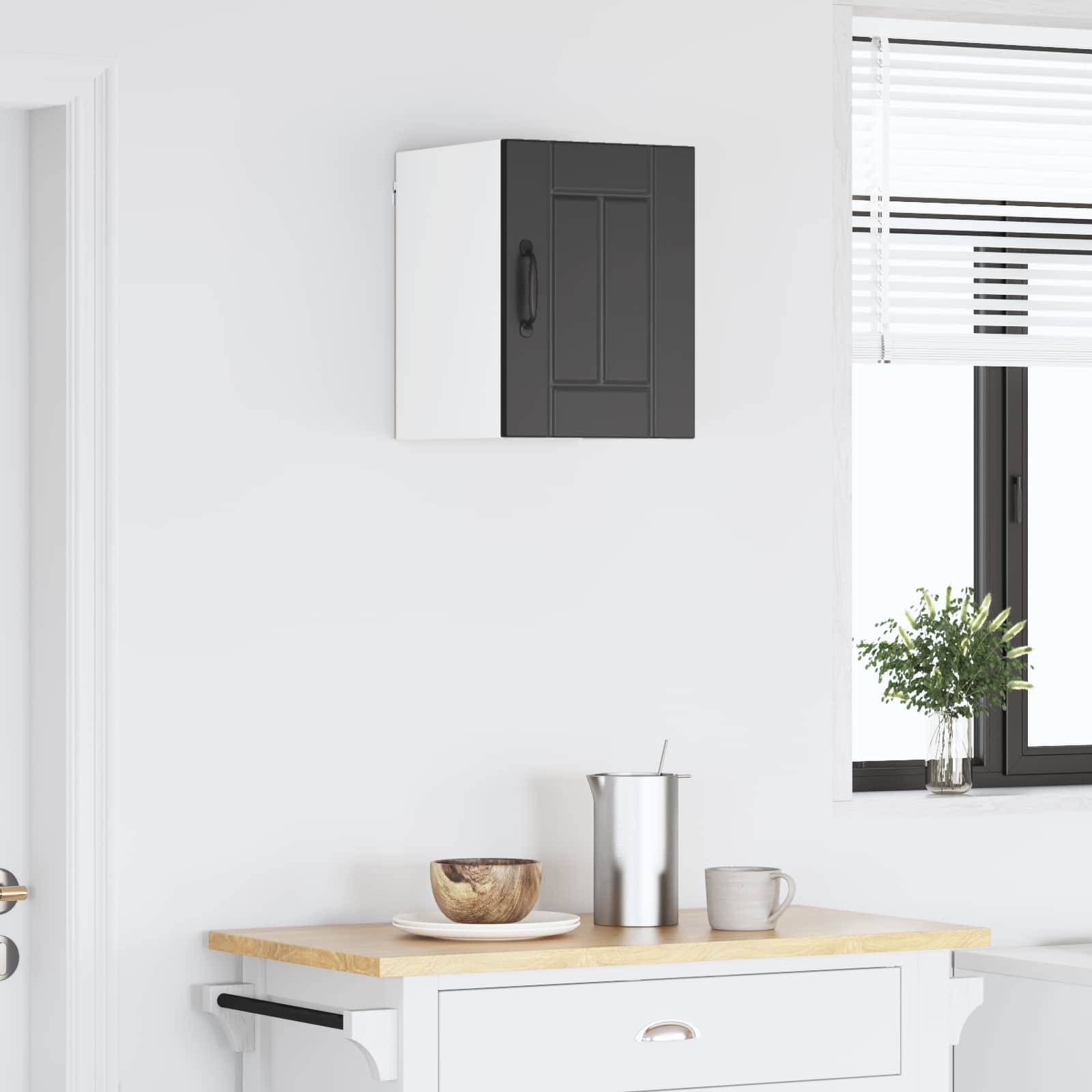 Eine kleine Küche mit einer hellen Holzarbeitsplatte, einer Holzschüssel und einer Tasse. An der Wand befindet sich ein Küchenschrank und ein Fenster mit Jalousien.