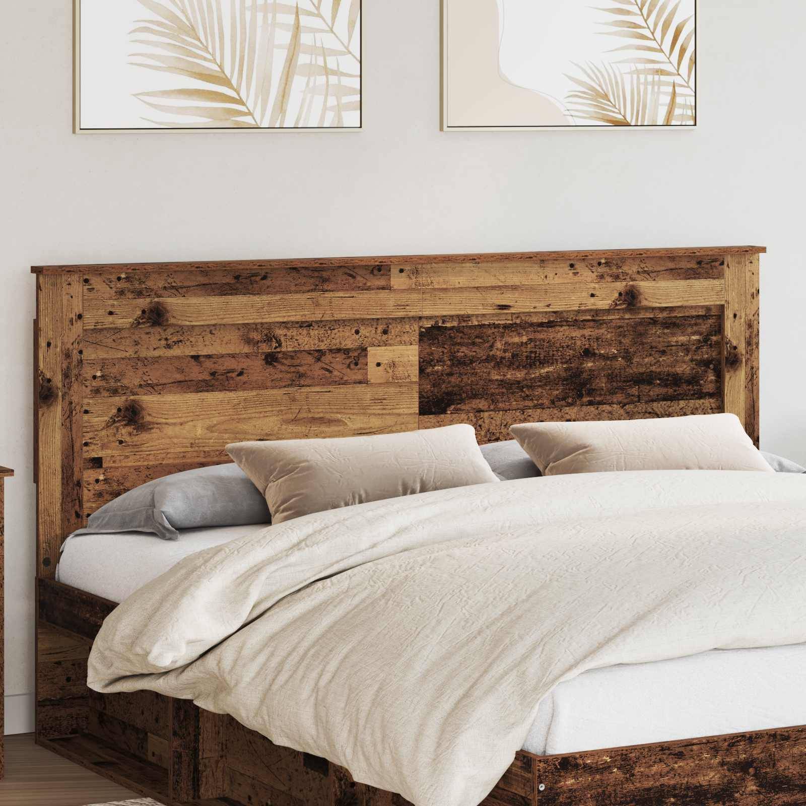 Ein gemütliches Schlafzimmer zeigt ein Holzbett mit beigefarbener Bettwäsche, zwei Kissen und abstrakte Pflanzenkunst, die an der Wand darüber hängt.