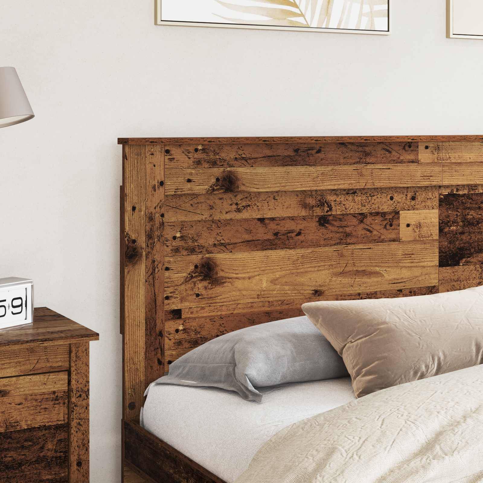 Ein gemütliches Schlafzimmer mit einem Holzbettgestell, beigen Kissen und einem passenden Nachttisch. Eine Lampe steht auf dem Nachttisch.