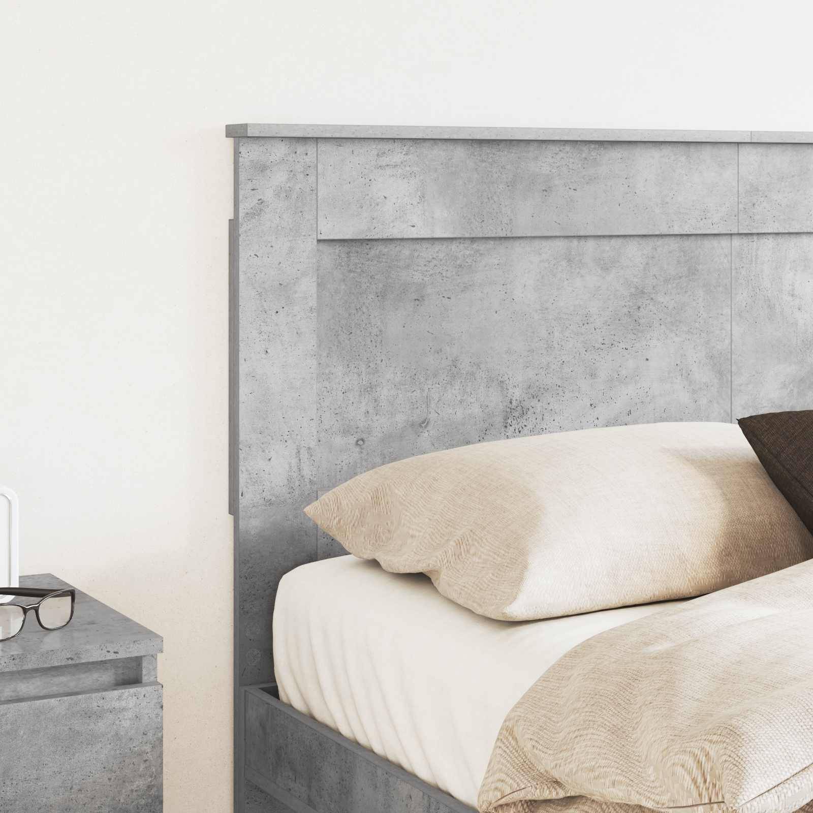 Ein minimalistisches Schlafzimmer mit Betonkopfteil und heller Bettwäsche, mit einem Nachttisch aus Holz und einer weißen Lampe.