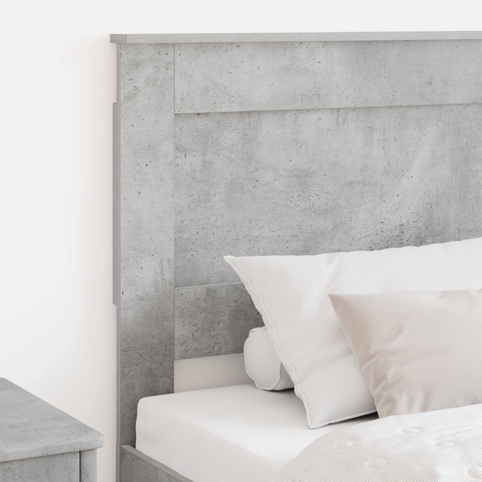 Ein modernes, minimalistisches Schlafzimmer mit einem hellgrauen Betonkopfteil, weißer Bettwäsche und zwei Kissen, das eine saubere und ruhige Atmosphäre schafft.