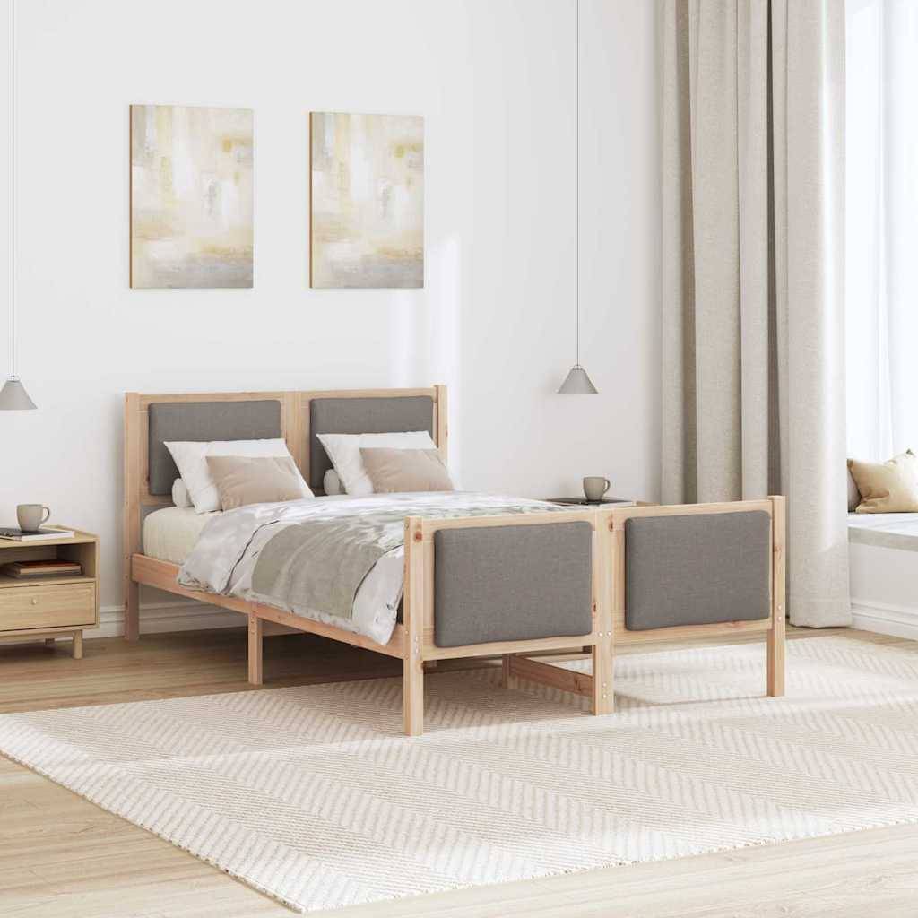 Ein minimalistisches Schlafzimmer mit einem Holzbett, grauer Bettwäsche und zwei abstrakten Gemälden an der Wand. Licht fällt durch ein großes Fenster neben dem Bett herein.