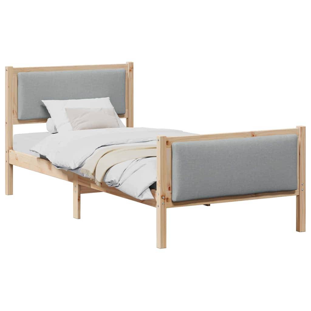 Ein Holz-Einzelbett mit grauen Stoffpaneelen am Kopf- und Fußteil, ausgestattet mit einem ordentlich bezogenen weißen Bettwäscheset und Kissen.