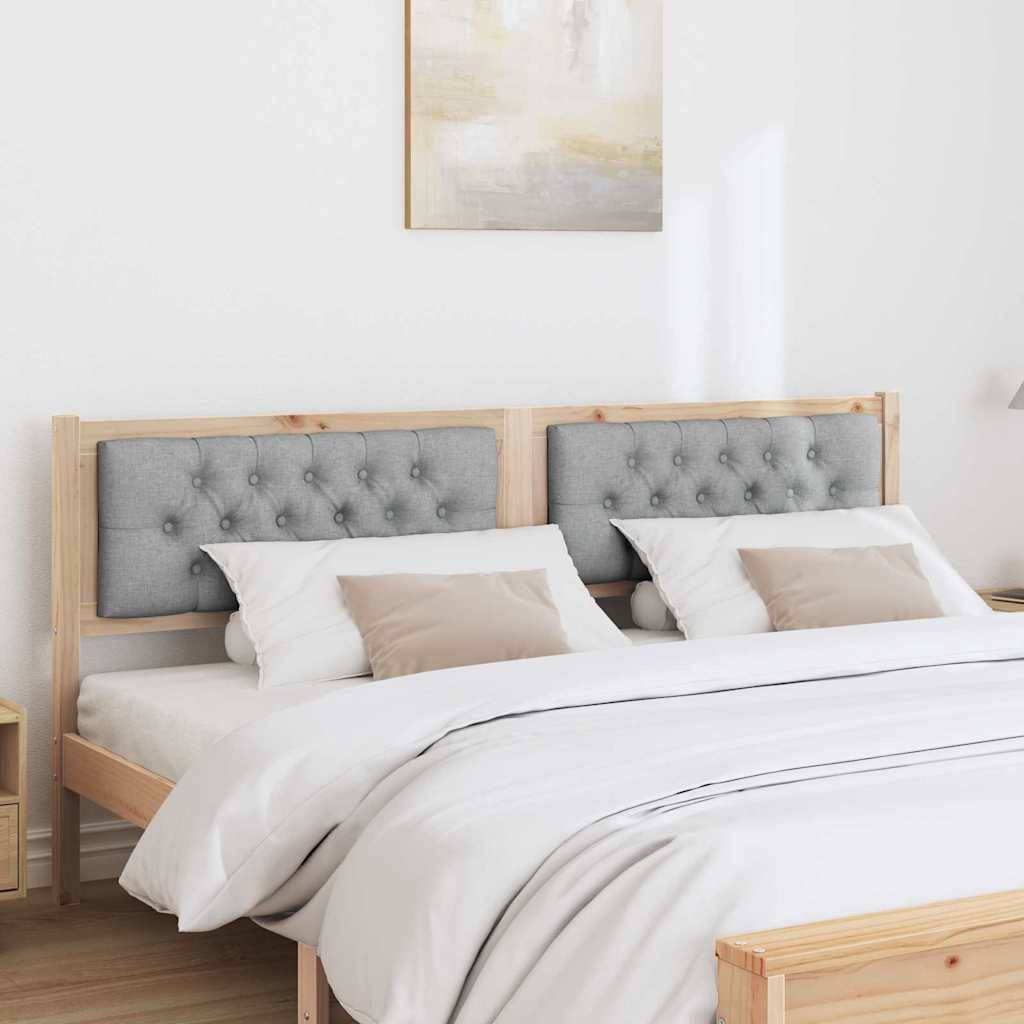 Ein ordentlich gemachtes Bett mit Holzrahmen und gepolstertem Kopfteil, ausgestattet mit weißen Betttüchern und grauen Kissen, in einer minimalistischen Schlafzimmereinrichtung.