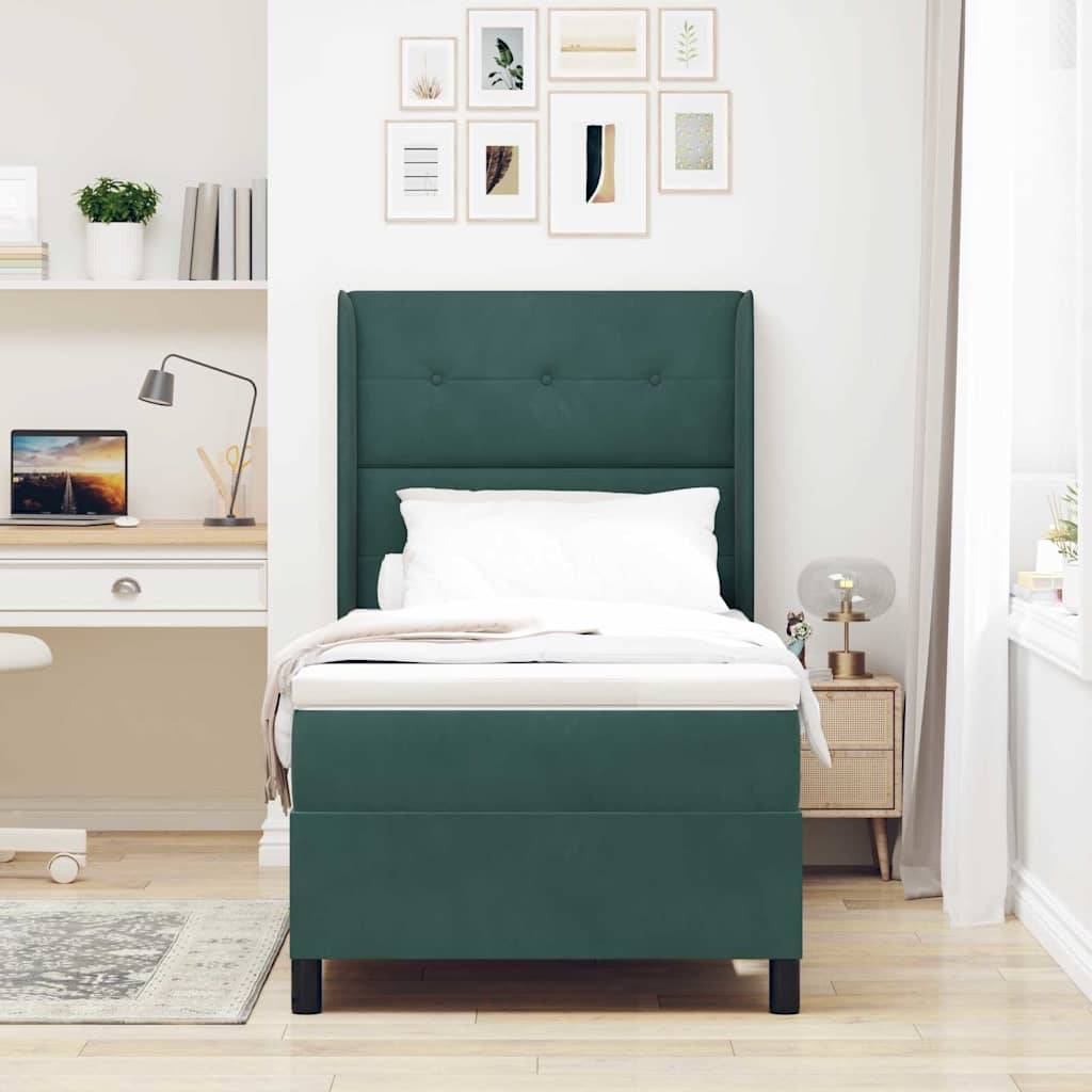 Ein modernes Schlafzimmer mit einem einzelnen grünen Bett, einem weißen Schreibtisch mit einem Laptop, Büchern, Pflanzen und einer Lampe auf Regalen. Kunstrahmen schmücken die Wand.