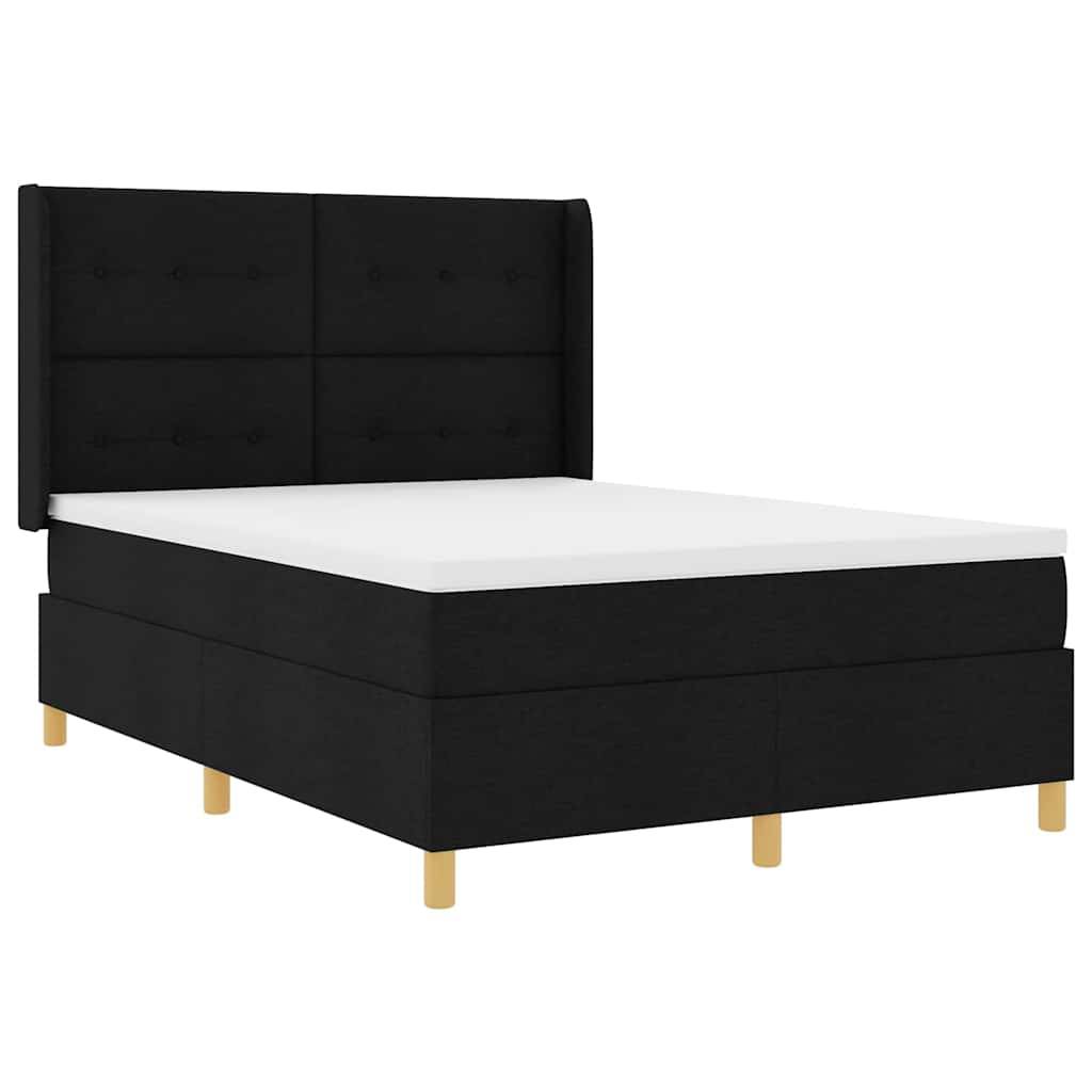 Ein großes schwarzes Boxspring-Bett mit einem hohen, gepolsterten Kopfteil und mehreren hölzernen Beinen, von vorne betrachtet.
