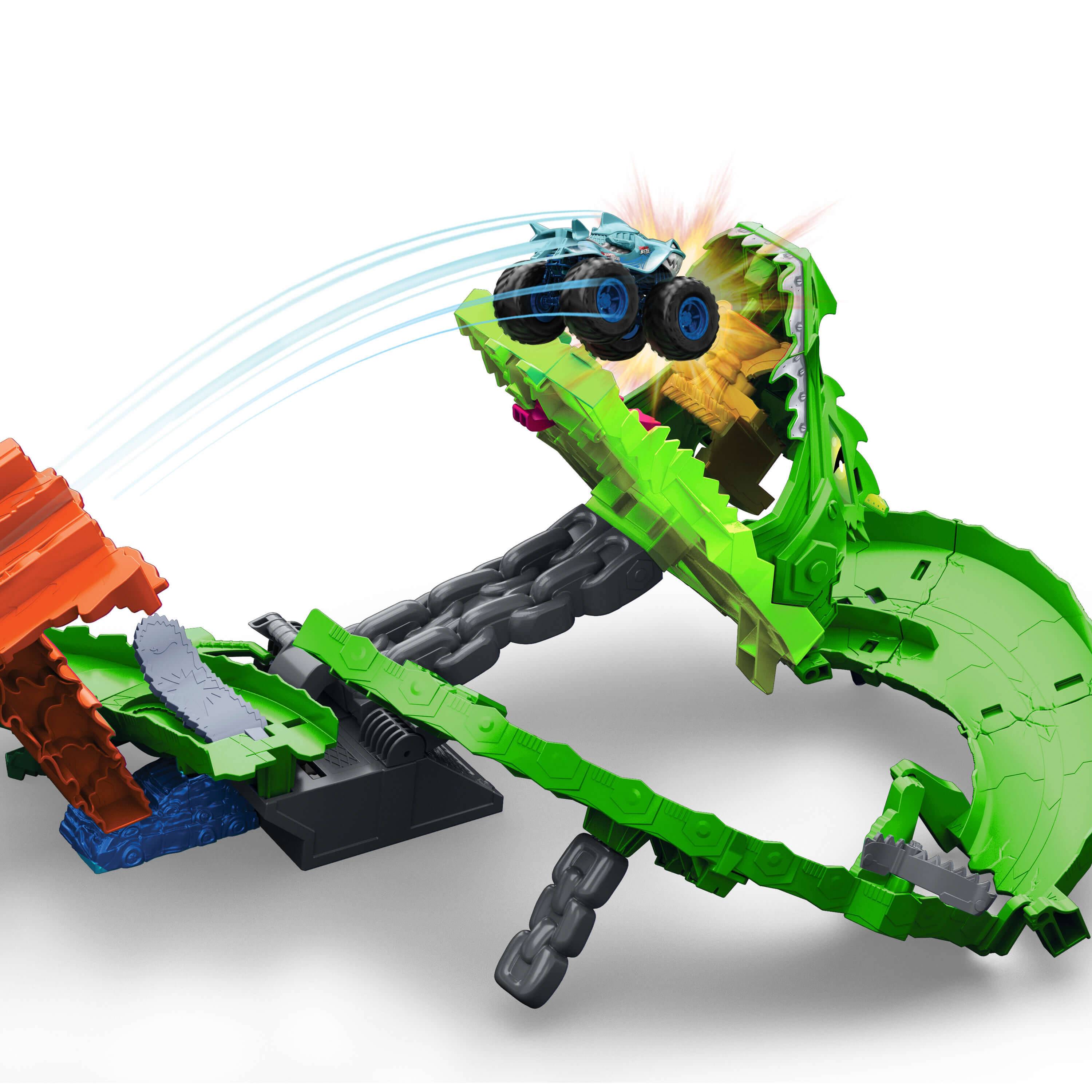 Ein blauer Spielzeugauto springt durch eine grüne, drachen-thematische Looping-Bahn mit einer orangefarbenen Rampe und demonstriert dabei Geschwindigkeit und Dynamik.