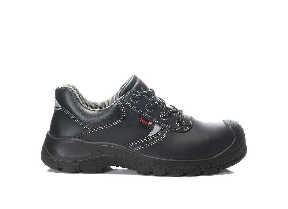 Ein schwarzer Arbeitsschuh mit einer dicken Sohle, weißer Naht und Metallösen, konzipiert für Strapazierfähigkeit und Sicherheit, auf weißem Hintergrund platziert.