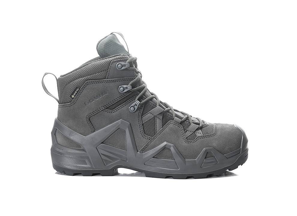 Grauer Wanderschuh mit robuster Sohle, knöchelhoher Konstruktion und verstärkter Zehenpartie. Geeignet für Outdoor-Aktivitäten und raues Gelände.