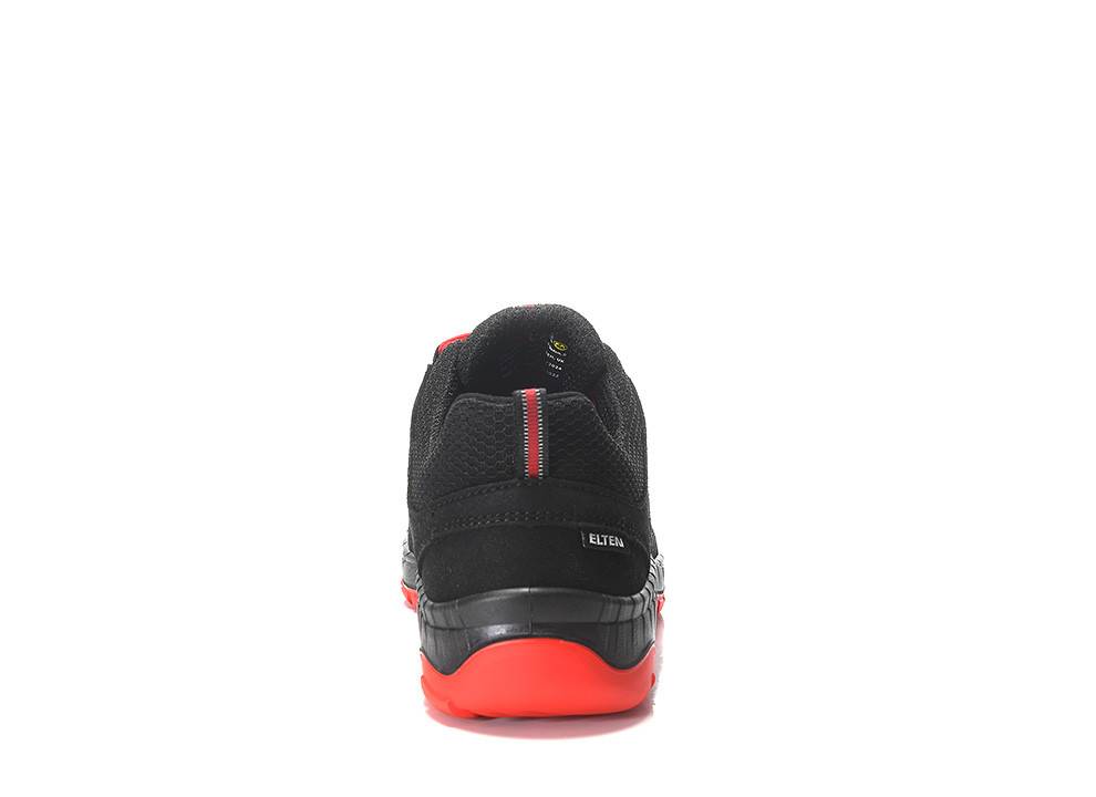 Ein schwarzer Schuh mit roten Akzenten, von hinten betrachtet, mit strukturiertem Design und einem sichtbaren Absatz mit einem Streifen und Branding an der Seite.