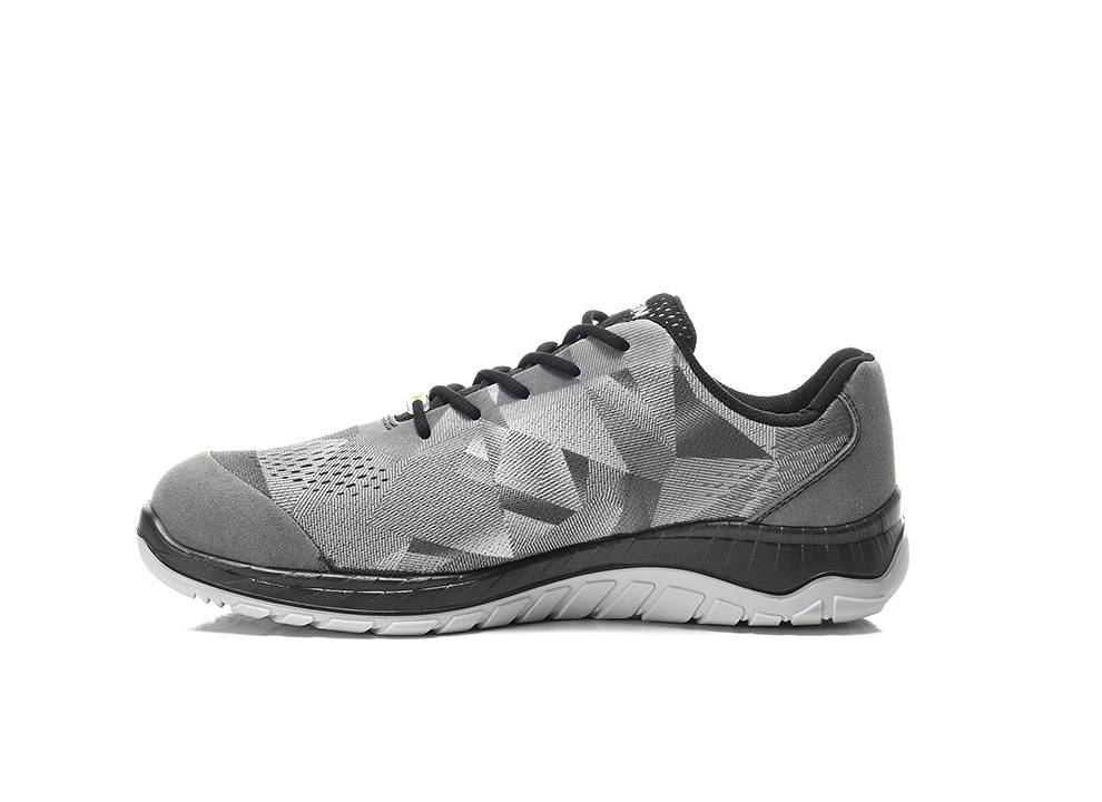 Grauer Sportschuh mit geometrischem Muster, schwarzen Schnürsenkeln und einer weiß-schwarzen Sohle, in Seitenansicht von rechts vor einem weißen Hintergrund.