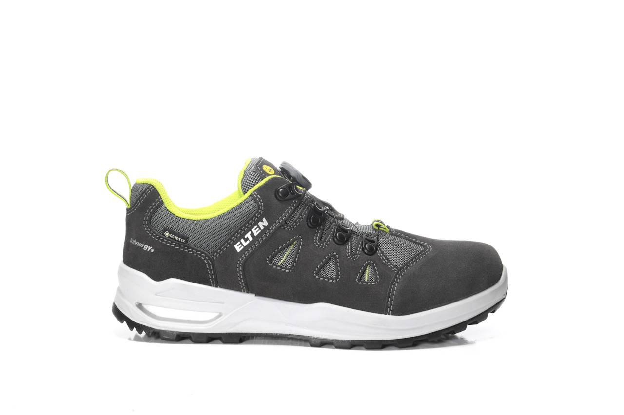Ein schwarzer und grauer Low-Top-Sneaker mit weißer Sohle und neongrünen Akzenten. Markenname an der Seite, entwickelt für Komfort und Strapazierfähigkeit.