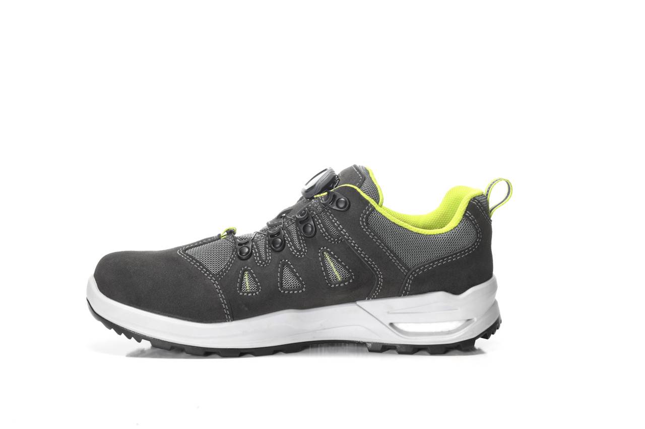 Ein schwarzer und grüner Sportschuh mit einer dicken weißen Sohle und hellgrüner Innenausstattung, ausgestattet mit mehreren Ösen und Netzdetails.