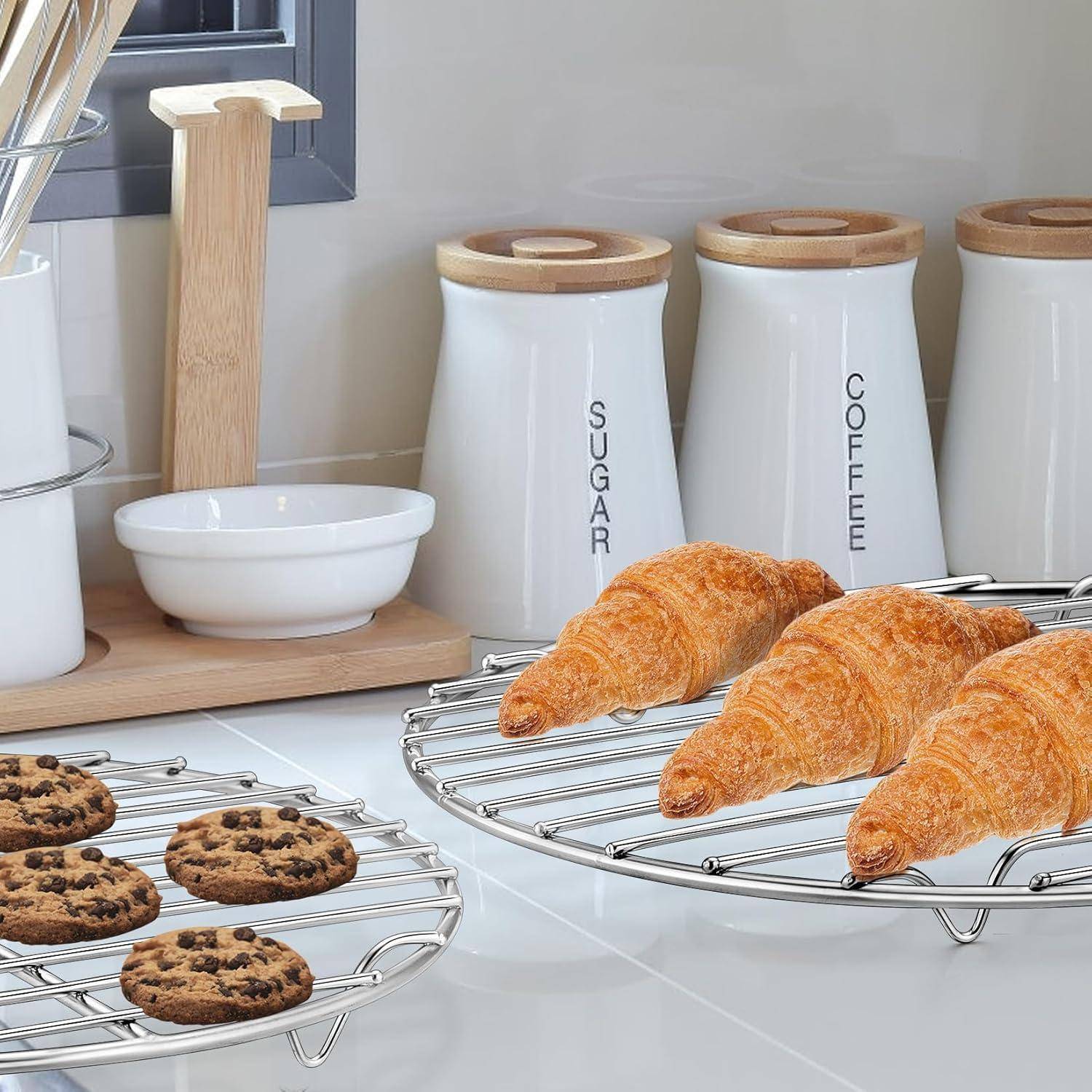 Eine Küchenarbeitsplatte mit Croissants auf einem Drahtgestell, Keksen auf einem anderen Gestell und Gläsern, die mit ‚Zucker' und ‚Kaffee' beschriftet sind, im Hintergrund.