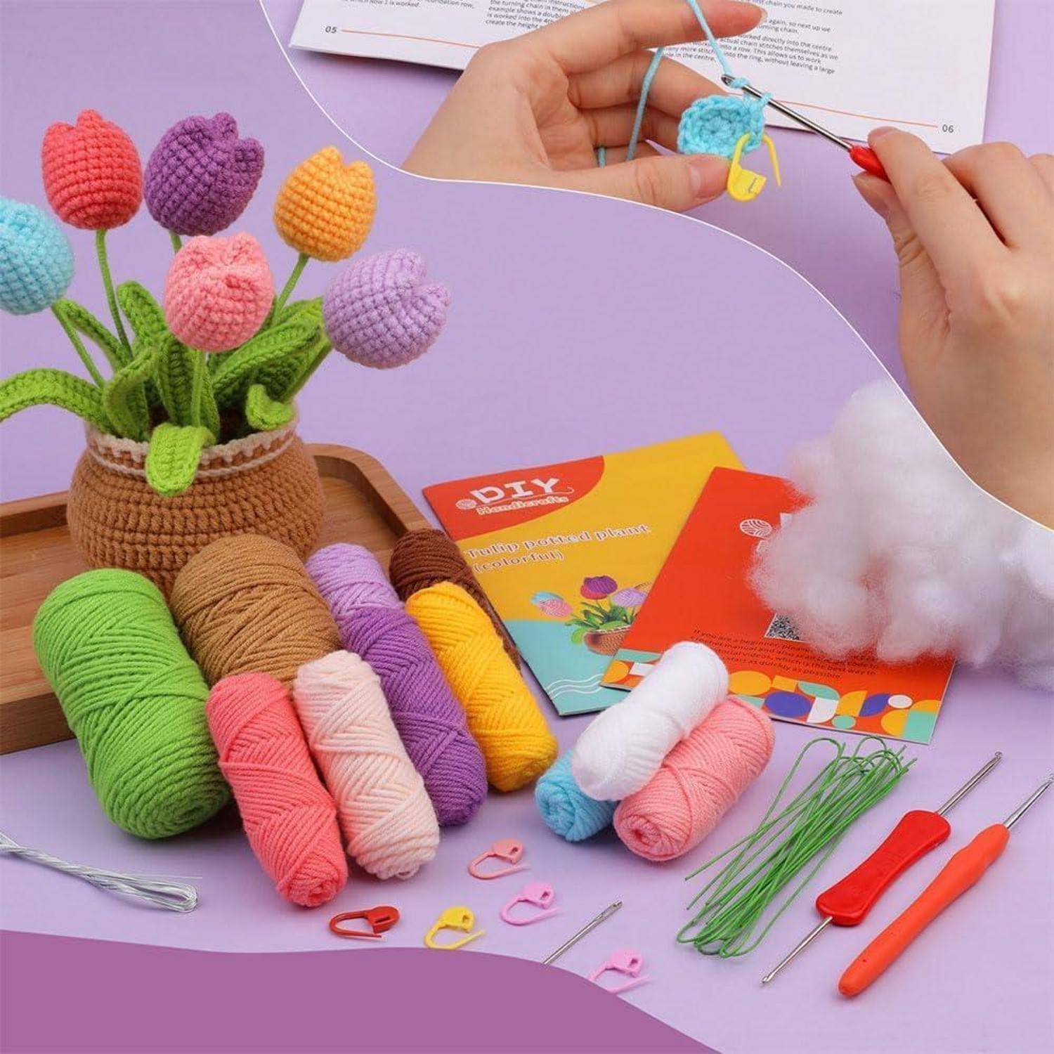 Ein Strickset mit Garn, Häkelnadeln und einer Schritt-für-Schritt-Anleitung zum Herstellen bunter Tulpenblumen, teilweise bereits gefertigt.
