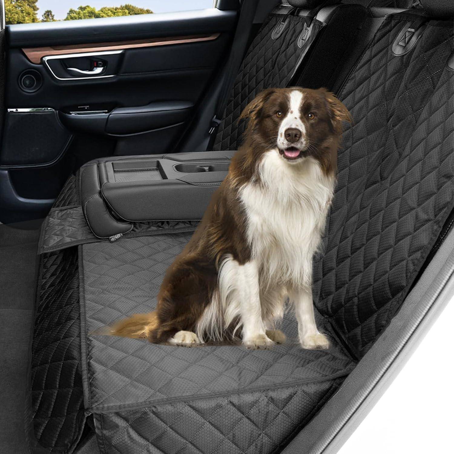 Hund sitzt auf einer gesteppten Sitzauflage auf dem Rücksitz eines Autos und blickt nach vorn. Das Interieur ist sauber und mit Leder ausgeschlagen.