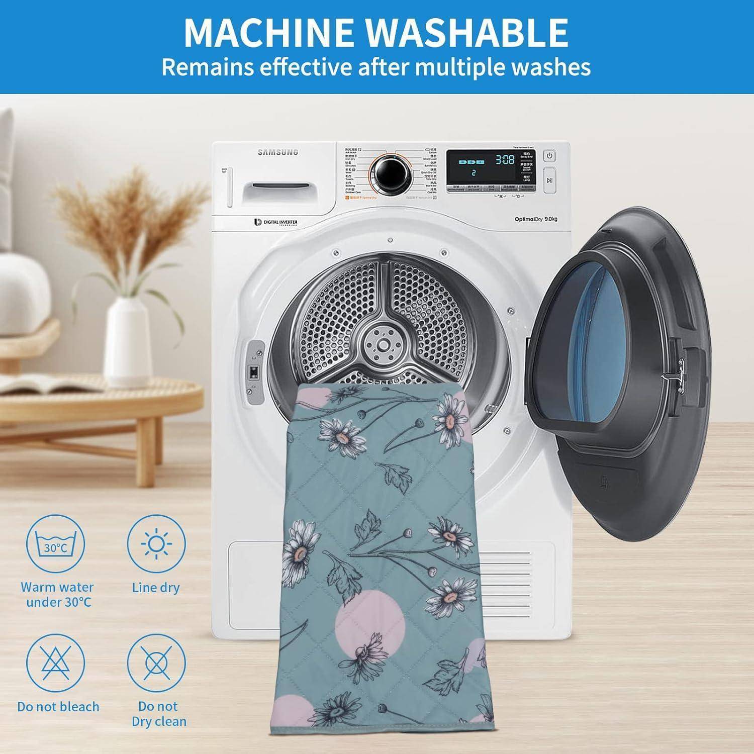 Eine weiße Waschmaschine mit geöffneter Tür. Ein Tuch mit Blumenmuster hängt daran. Text besagt: 